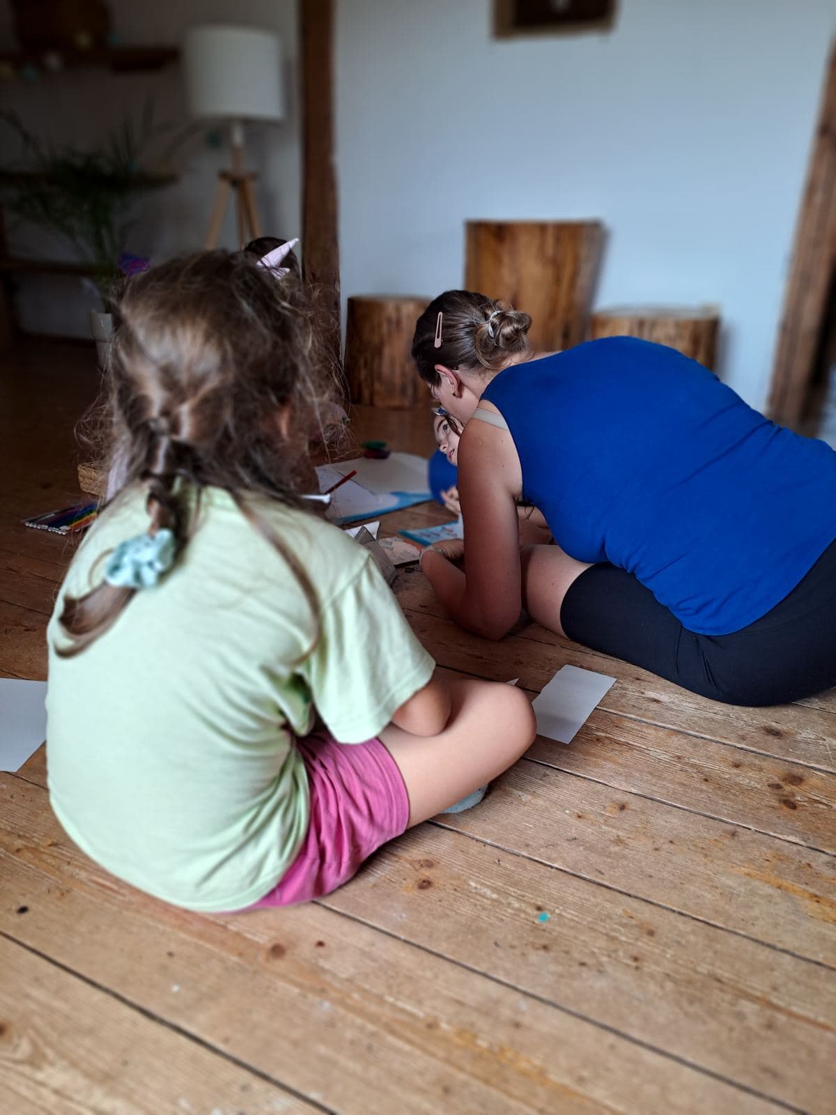 Průvodkyně a děti nad společnou prací